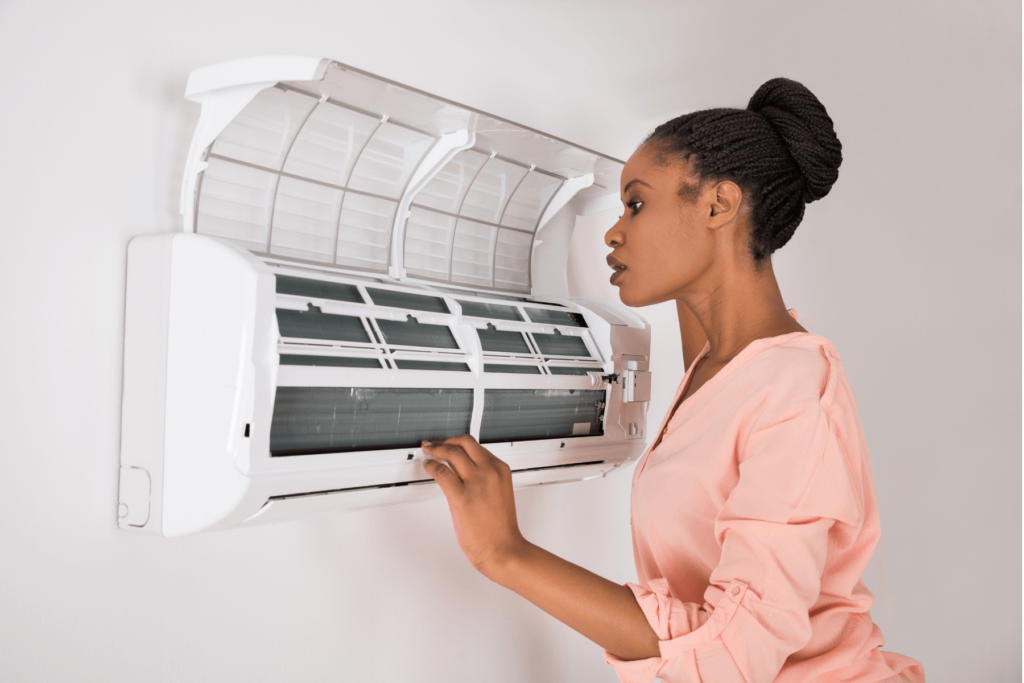 Homeowner checking mini-split AC unit filter replacement.