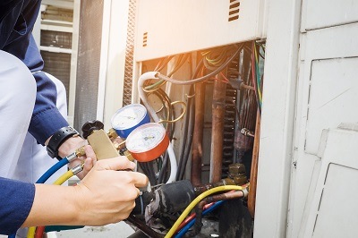 Davis Heating & Air Expert Checking AC Unit for Customer