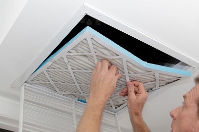 Davis Heating & Air Specialist Removing Dirty Old Air Filter From Air Filtering System