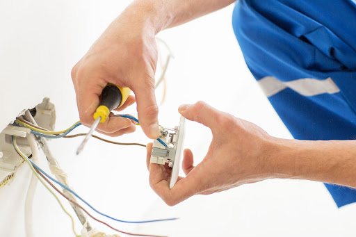Davis electrician installing outlet.