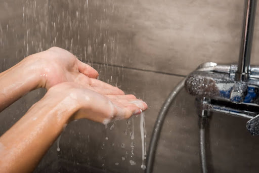 A person feeling shower water drops.